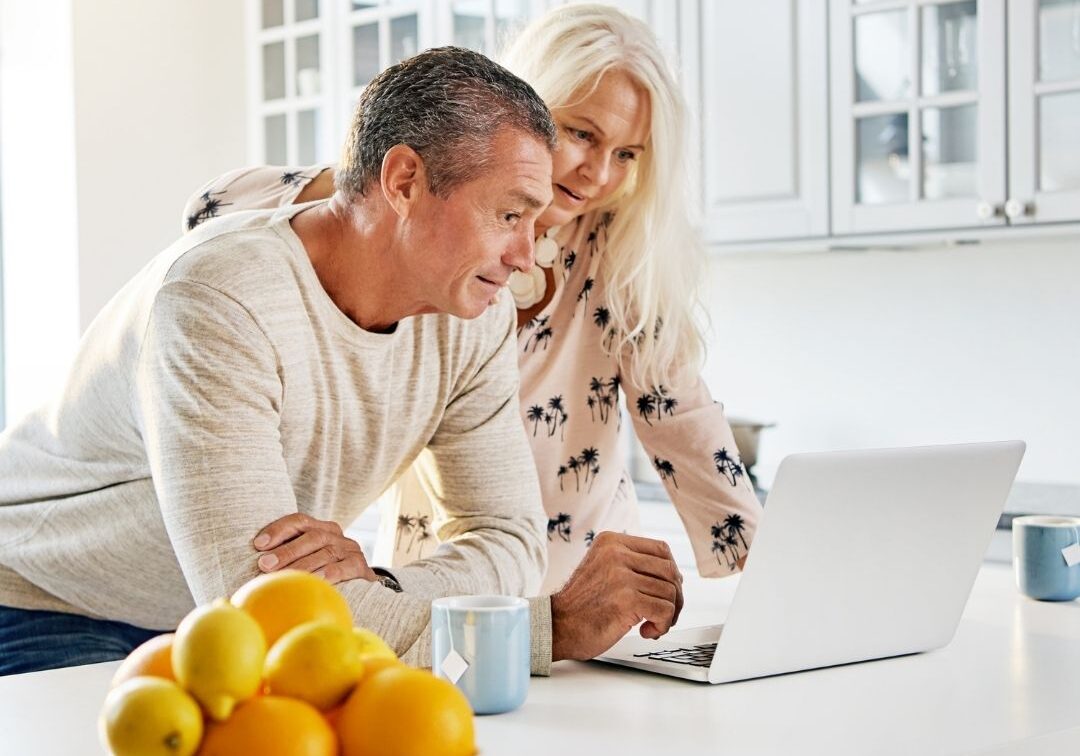 older couple using laptop in kitchen